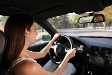 Woman holding steering wheel while driving car