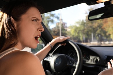 Emotional woman behind steering wheel driving car