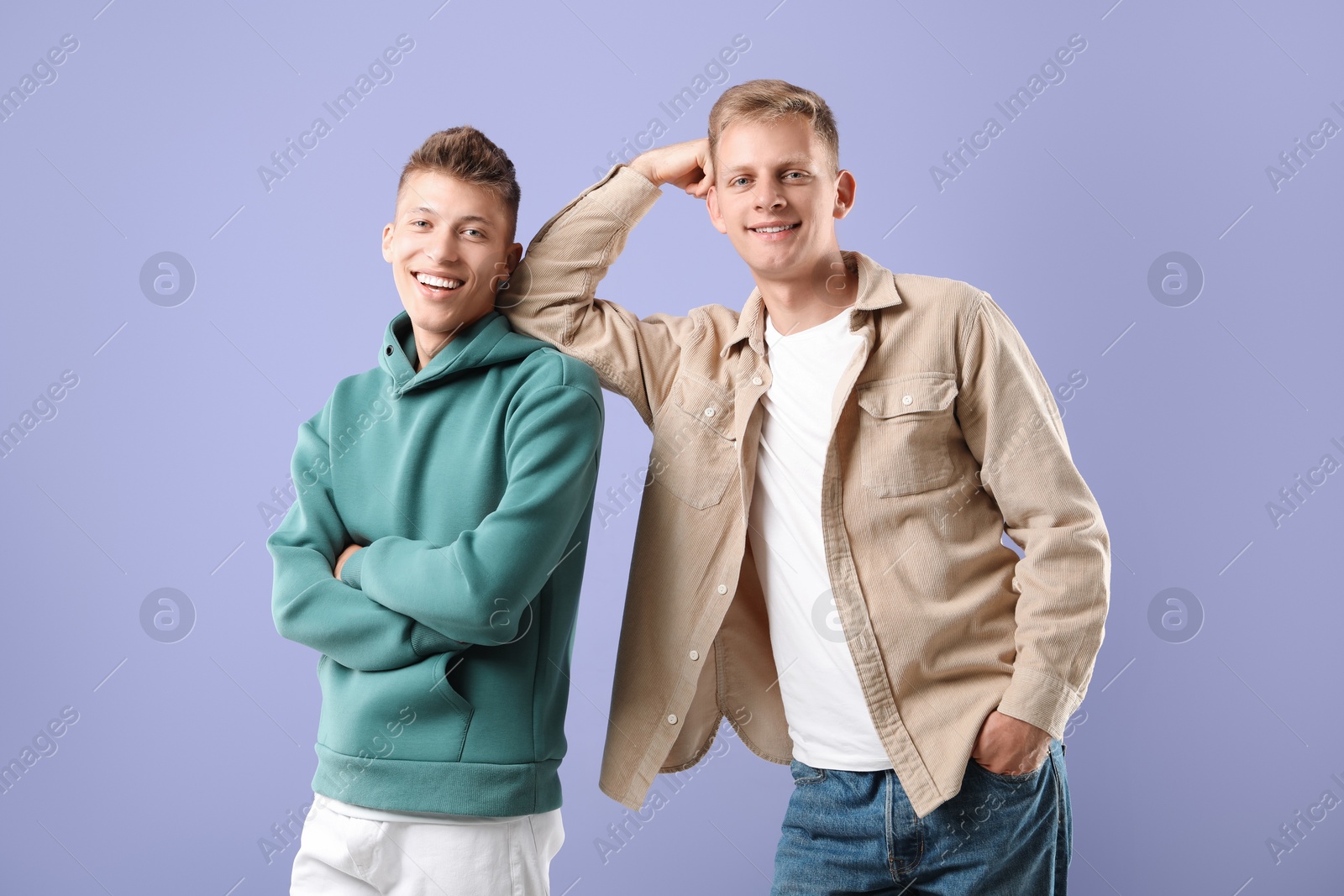 Photo of Portrait of happy brothers on violet background