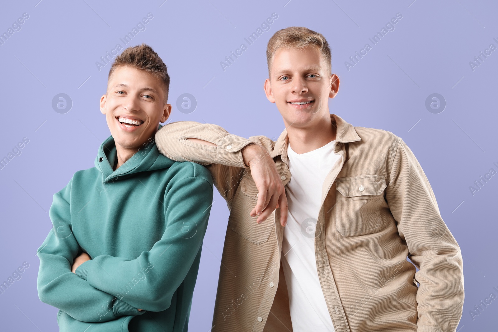 Photo of Portrait of happy brothers on violet background