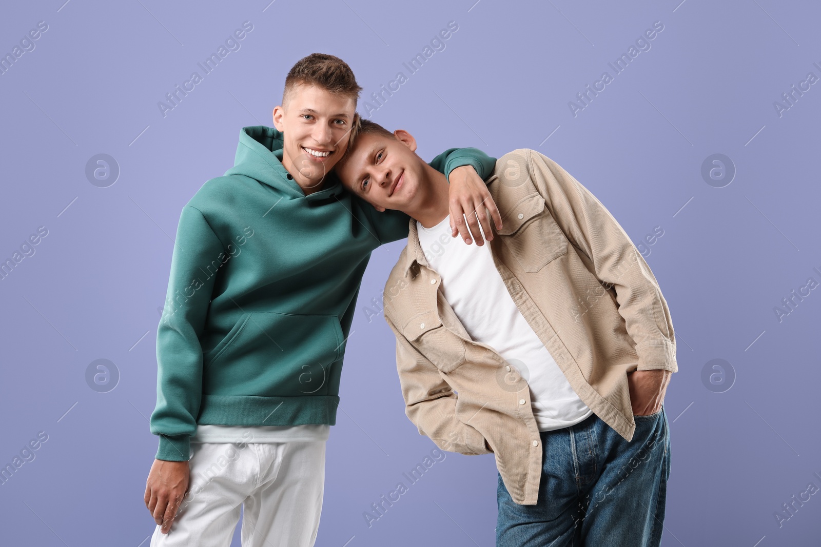 Photo of Portrait of happy brothers on violet background