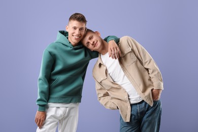 Portrait of happy brothers on violet background