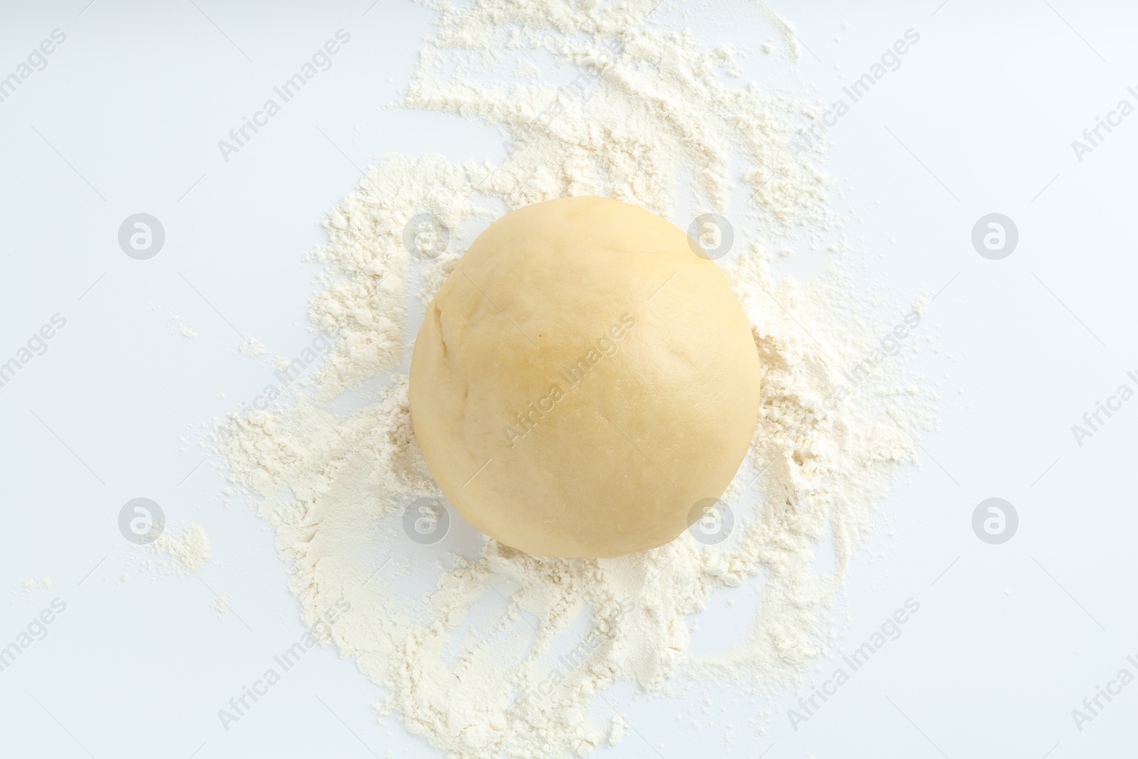 Photo of Cooking homemade pie. Raw dough and flour on white background, top view