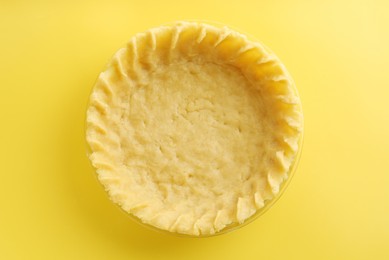 Photo of Cooking homemade pie. Raw dough on yellow background, top view