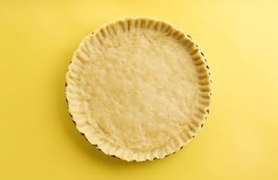 Photo of Cooking homemade pie. Raw dough on yellow background, top view