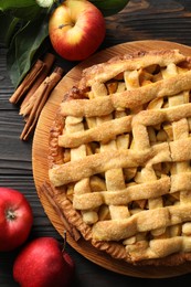 Tasty homemade apple pie and ingredients on wooden table, flat lay