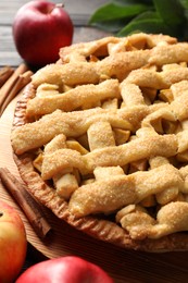 Photo of Tasty homemade apple pie and ingredients on table, closeup