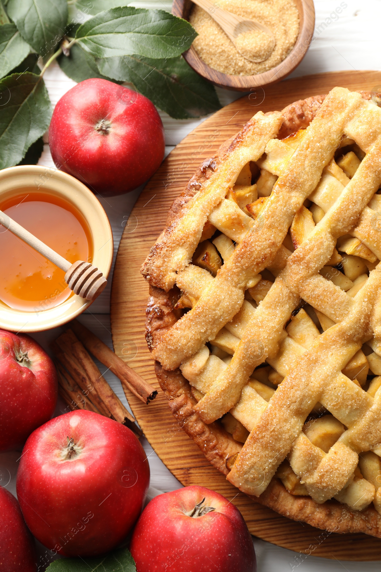 Photo of Tasty homemade apple pie and ingredients on white wooden table, flat lay