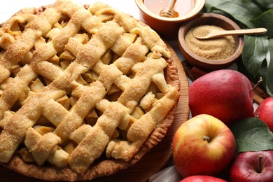 Photo of Tasty homemade apple pie and ingredients on table, closeup