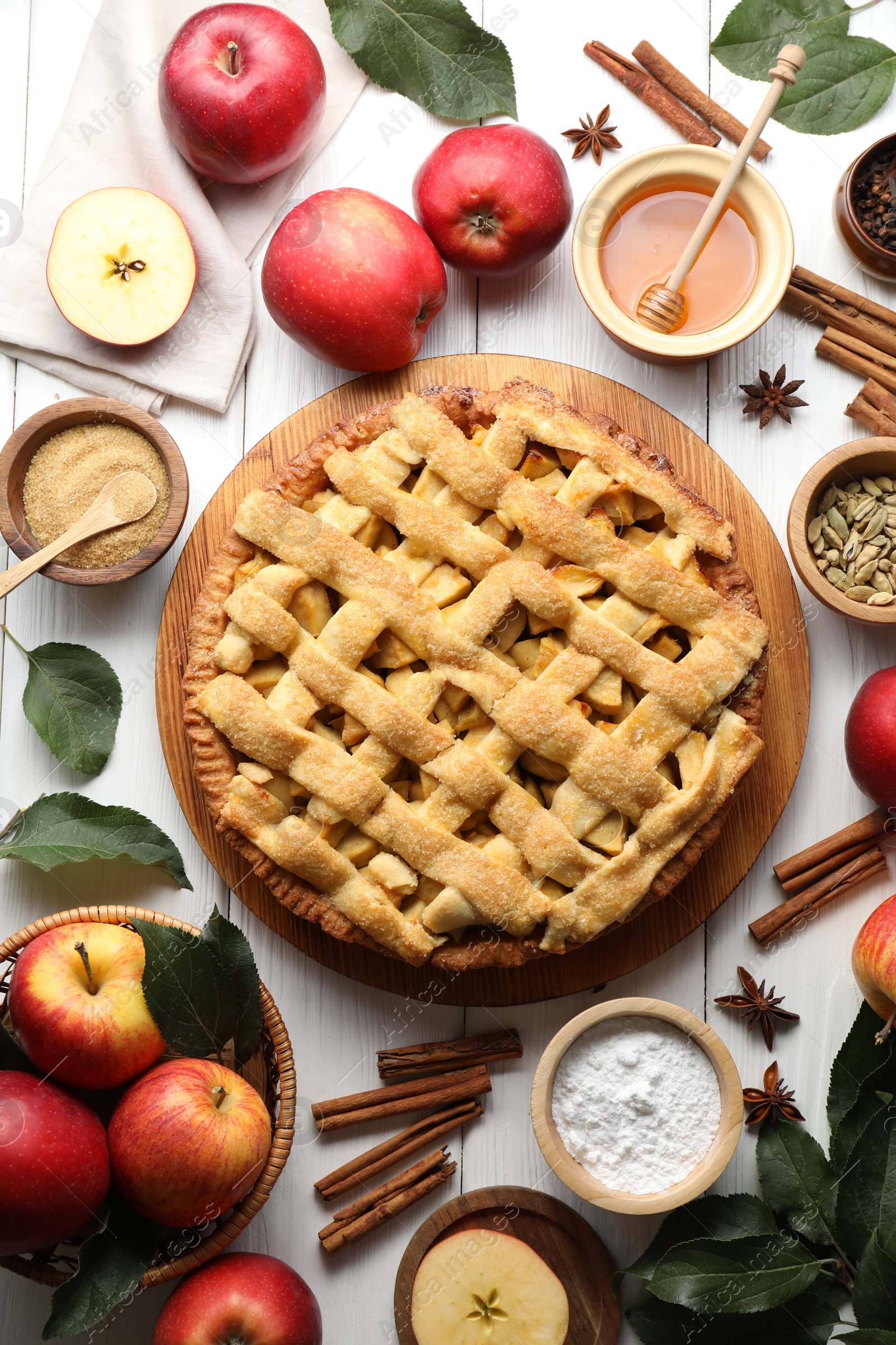 Photo of Tasty homemade apple pie and ingredients on white wooden table, flat lay