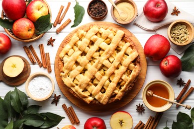 Tasty homemade apple pie and ingredients on white wooden table, flat lay