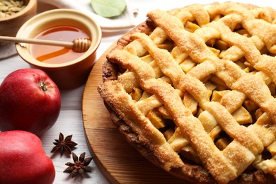 Tasty homemade apple pie and ingredients on white wooden table, closeup