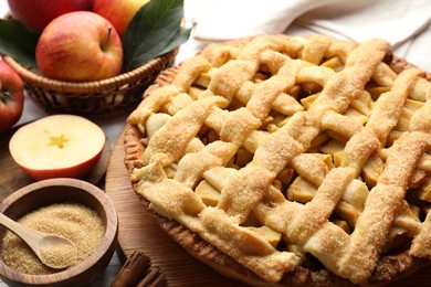 Photo of Tasty homemade apple pie and ingredients on table, closeup