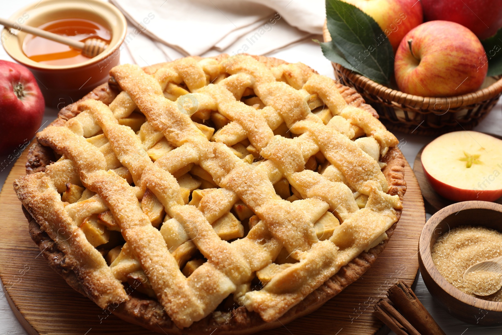 Photo of Tasty homemade apple pie and ingredients on table, closeup