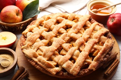 Photo of Tasty homemade apple pie and ingredients on table, closeup