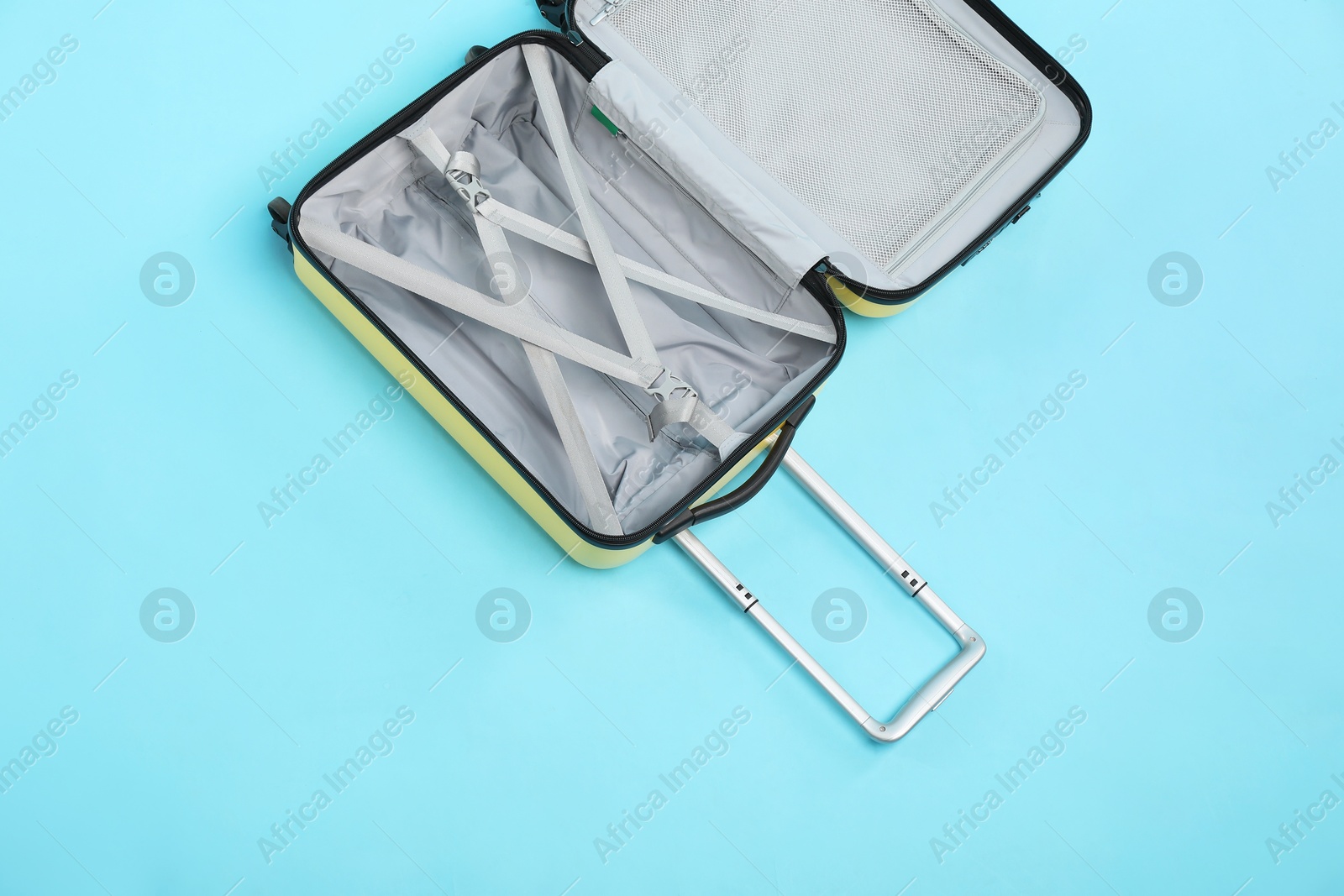 Photo of Open empty suitcase on light blue background, top view