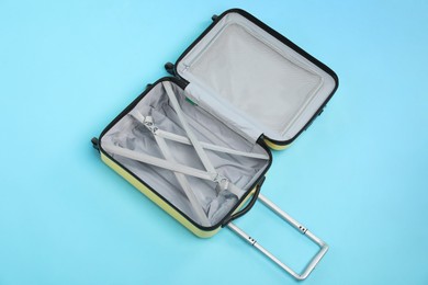 Photo of Open empty suitcase on light blue background, top view