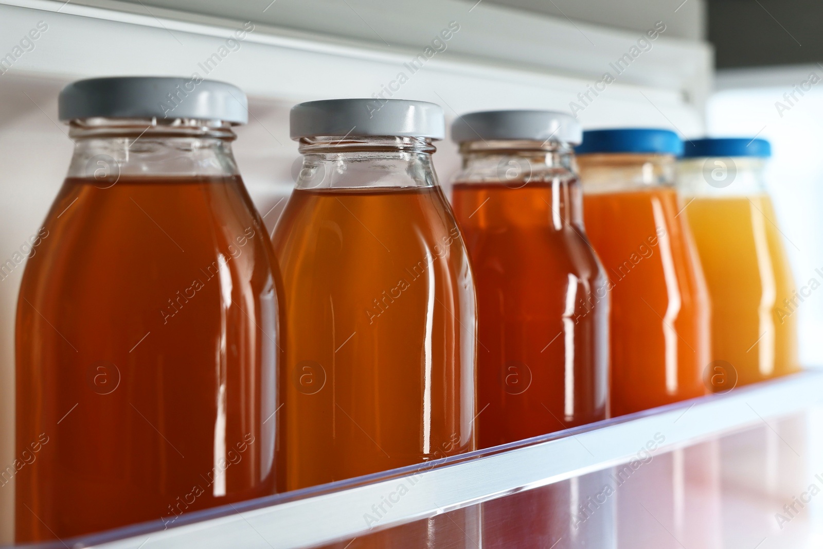 Photo of Many bottles of juice in refrigerator, closeup