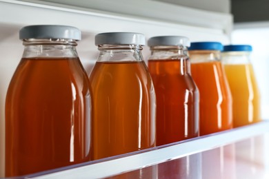 Many bottles of juice in refrigerator, closeup