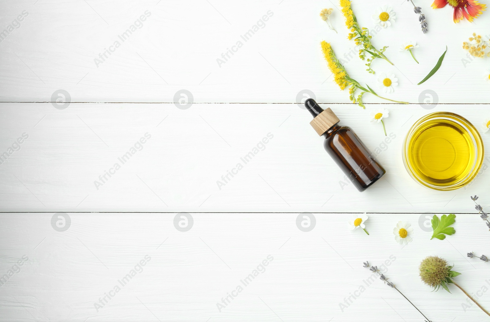 Photo of Tinctures and medicinal herbs on white wooden table, flat lay. Space for text