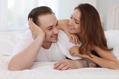 Happy couple spending time together on bed at home