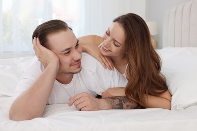 Happy couple spending time together on bed at home