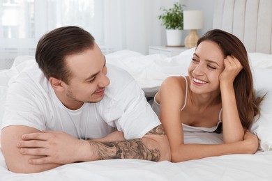 Happy couple spending time together on bed at home