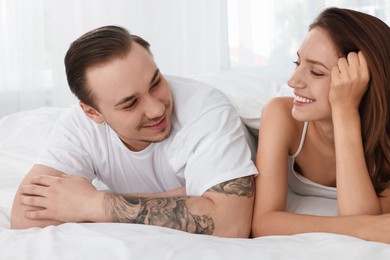 Happy couple spending time together on bed at home