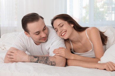 Happy couple spending time together on bed at home