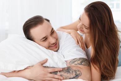 Happy couple spending time together on bed at home