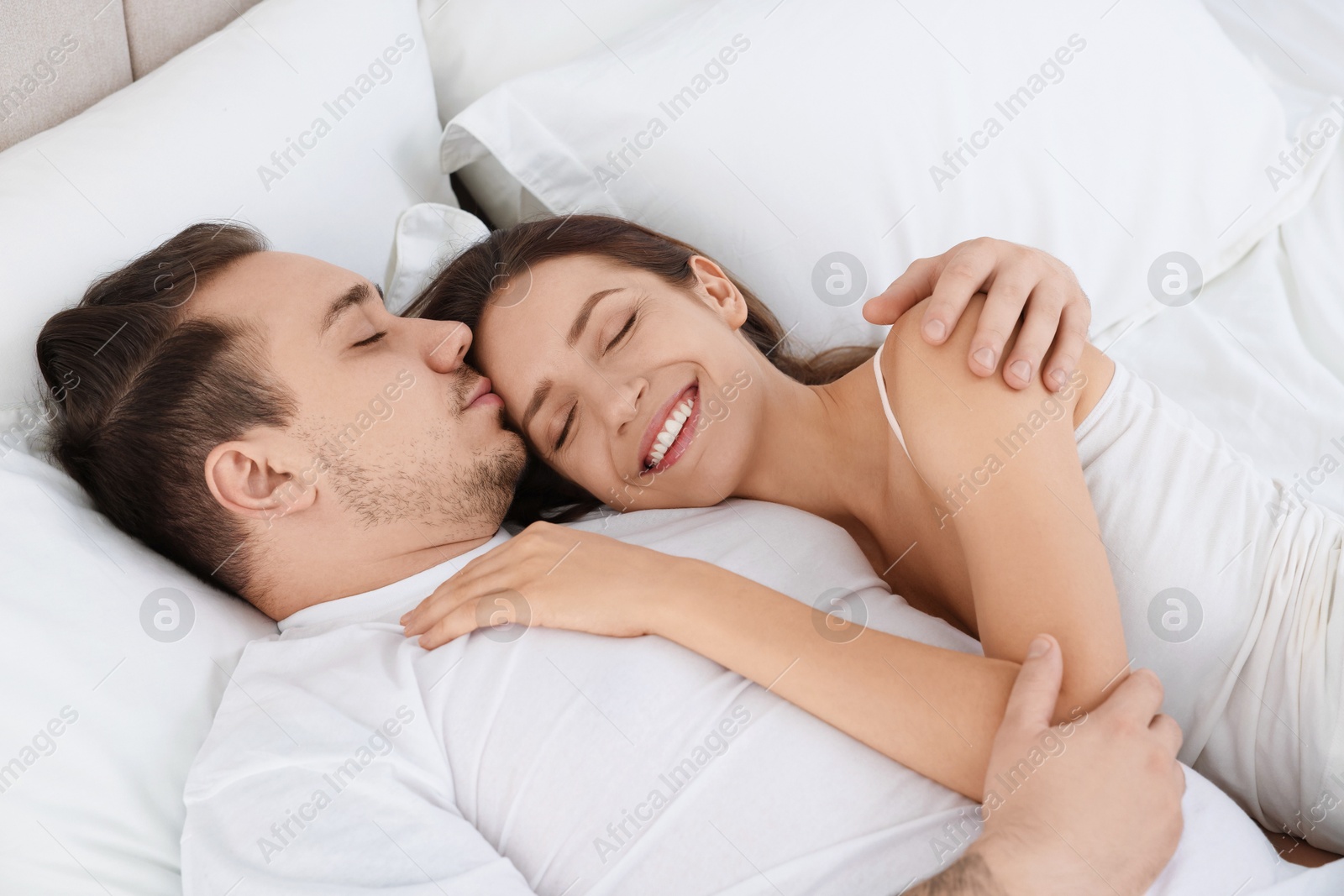 Photo of Happy couple spending time together on bed at home