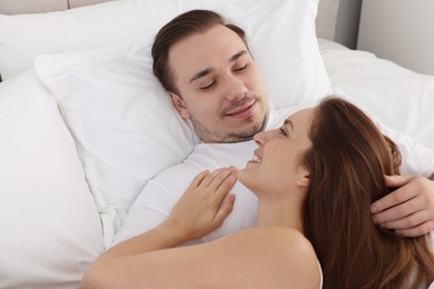 Happy couple spending time together on bed at home