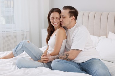 Photo of Happy couple spending time together on bed at home