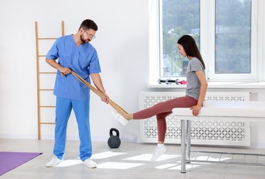 Photo of Physiotherapist working with patient in rehabilitation center