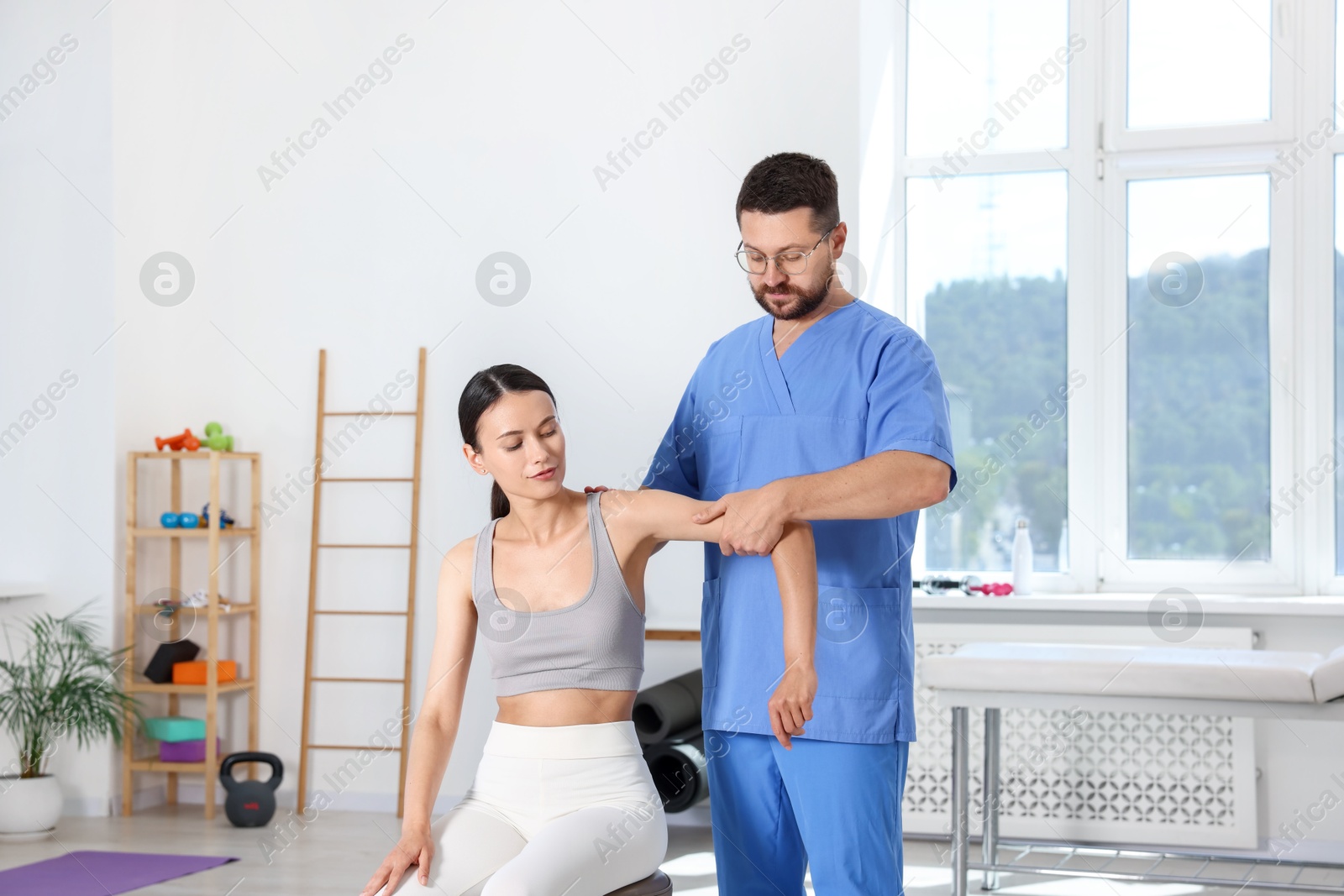 Photo of Physiotherapist working with patient in rehabilitation center