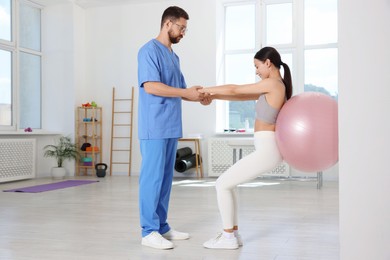 Photo of Physiotherapist working with patient in rehabilitation center