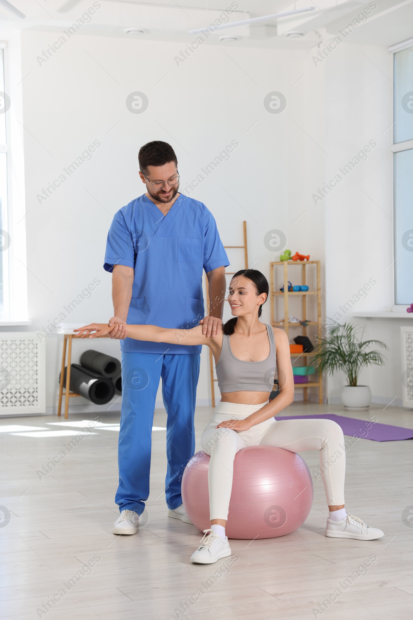 Photo of Physiotherapist working with patient in rehabilitation center