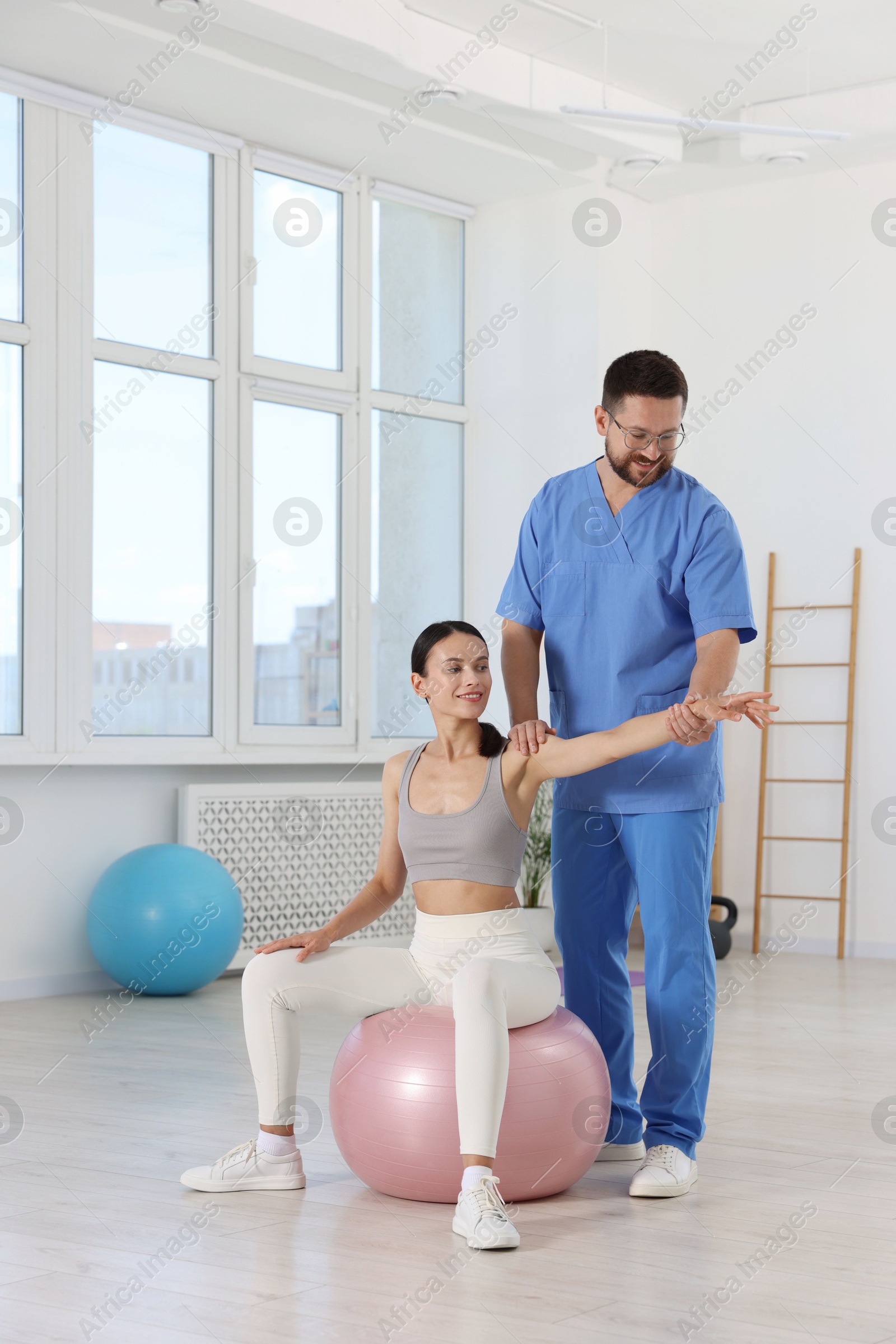 Photo of Physiotherapist working with patient in rehabilitation center