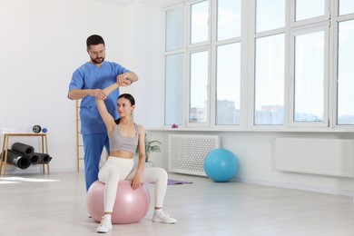 Photo of Physiotherapist working with patient in rehabilitation center