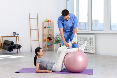 Photo of Physiotherapist working with patient in rehabilitation center