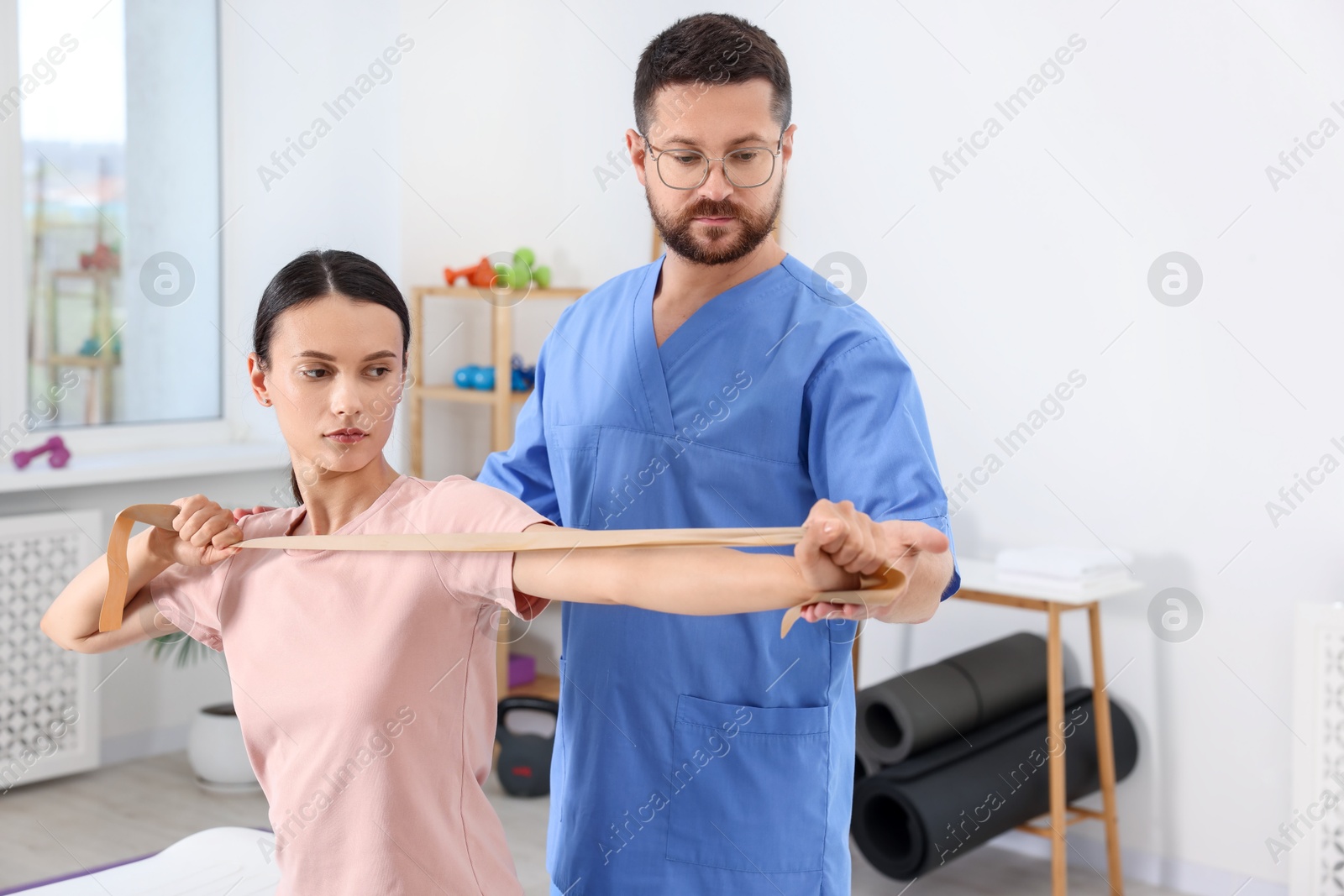 Photo of Physiotherapist working with patient in rehabilitation center