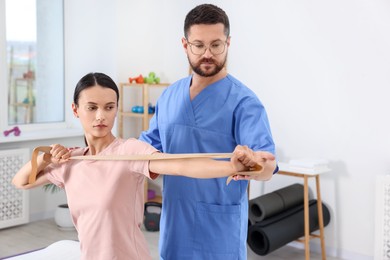 Photo of Physiotherapist working with patient in rehabilitation center