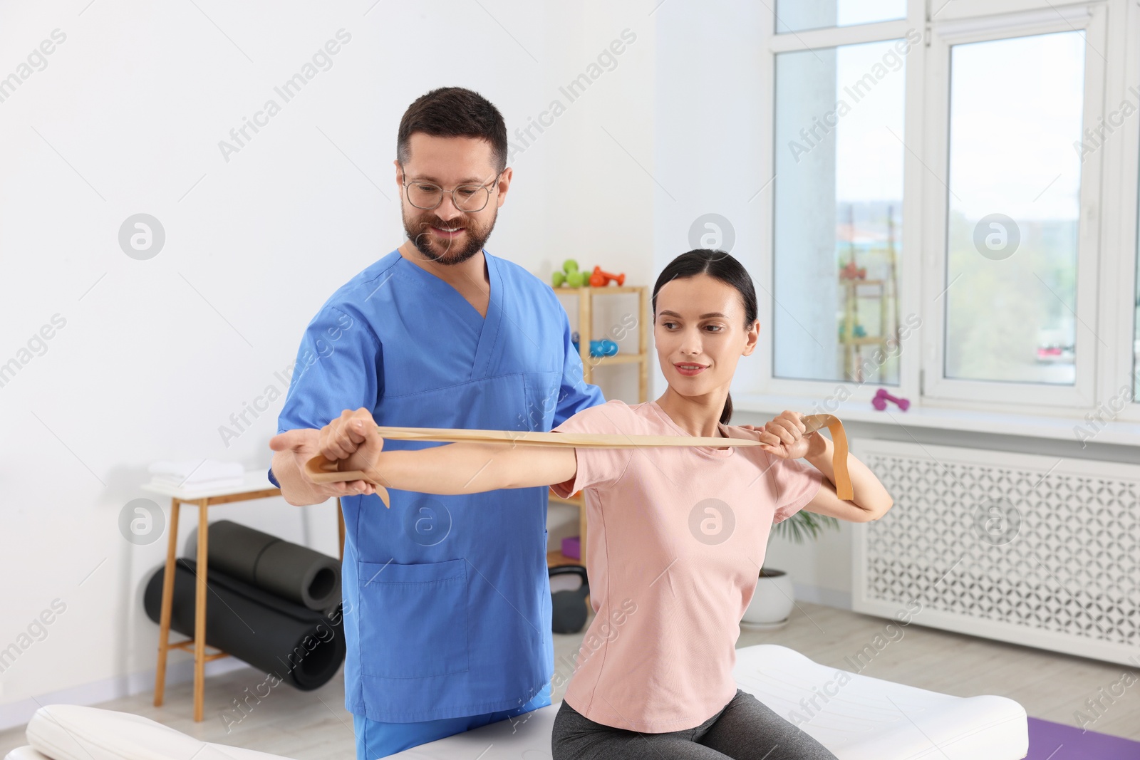 Photo of Physiotherapist working with patient in rehabilitation center