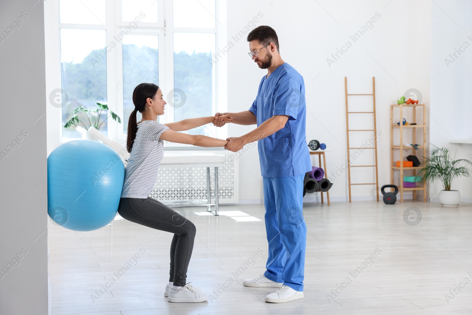 Photo of Physiotherapist working with patient in rehabilitation center