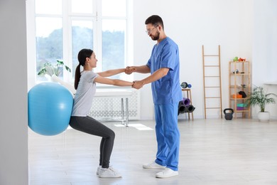 Photo of Physiotherapist working with patient in rehabilitation center