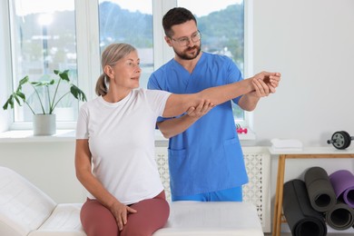 Physiotherapist working with senior patient in rehabilitation center