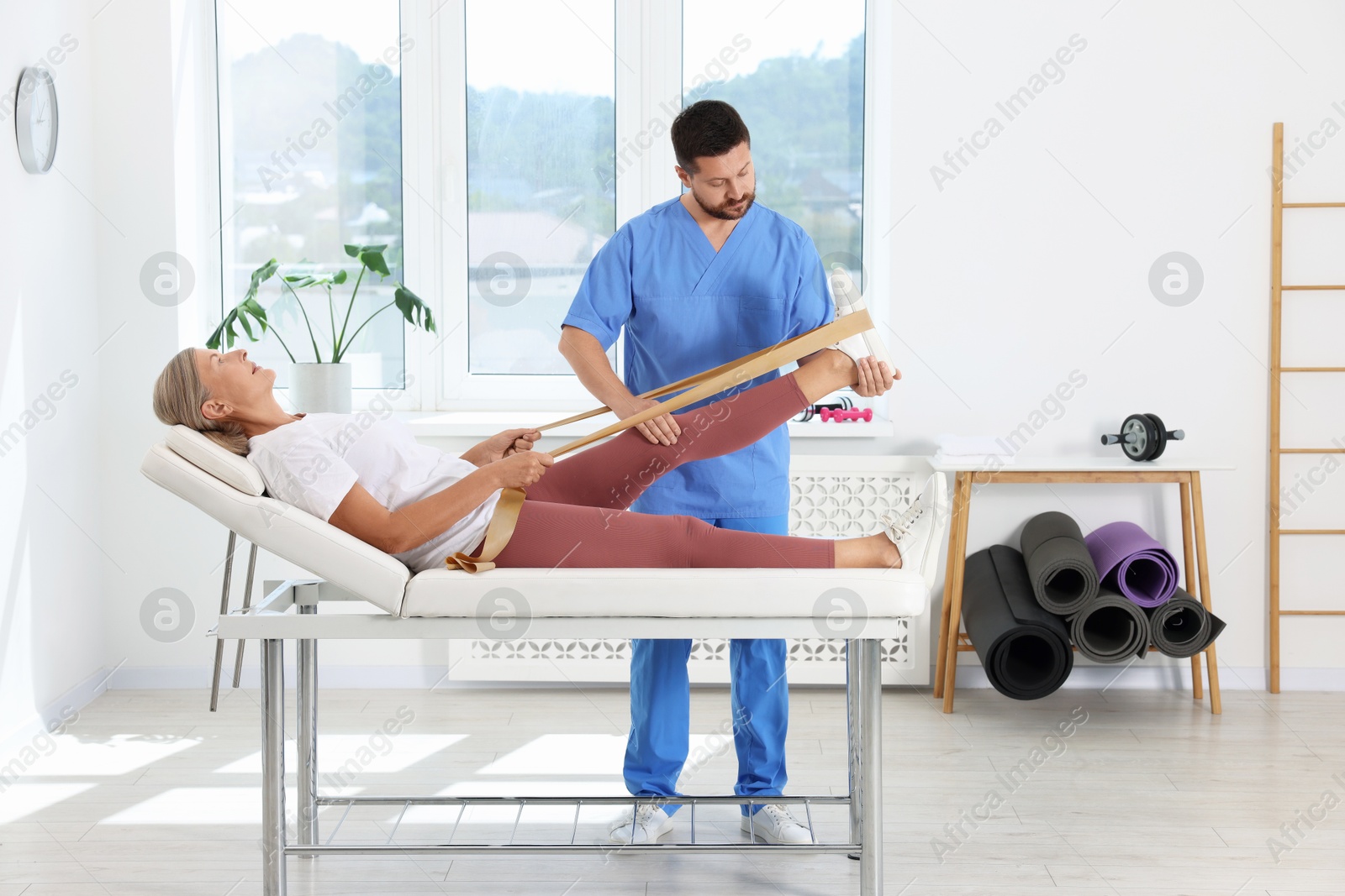 Photo of Physiotherapist working with senior patient in rehabilitation center