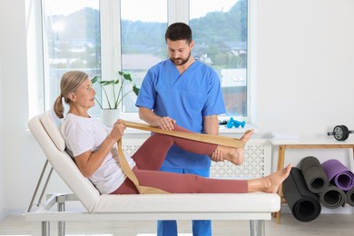 Physiotherapist working with senior patient in rehabilitation center