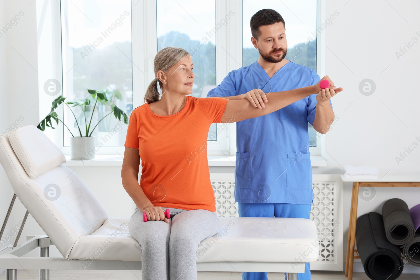 Photo of Senior patient exercising under physiotherapist supervision in rehabilitation center