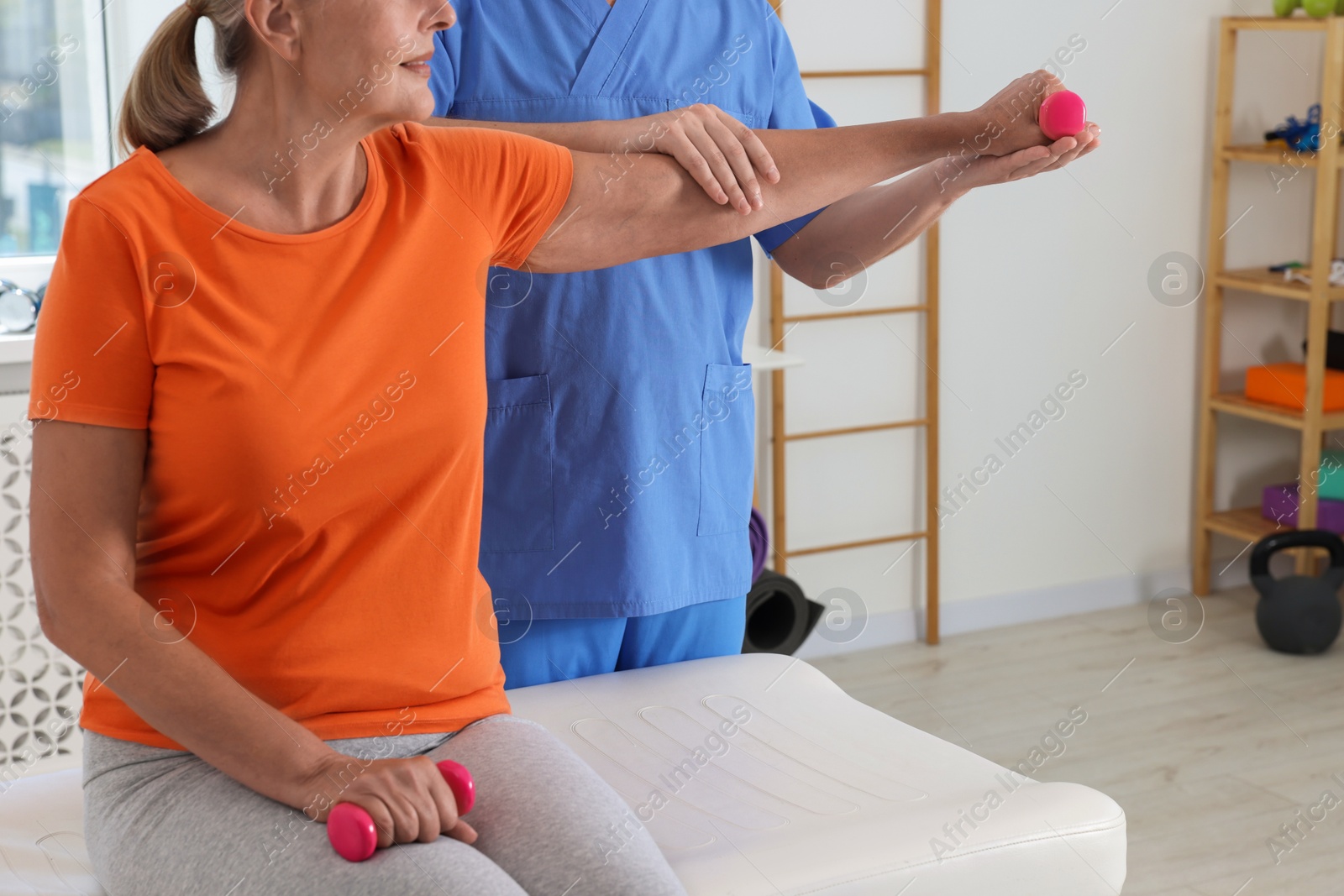 Photo of Senior patient exercising under physiotherapist supervision in rehabilitation center, closeup